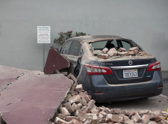 A car damaged by bricks falling during an earthquake is seen next to a downtown building in Napa, California 