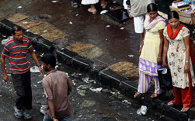 Sex workers solicit customers by the roadside in a red light area in Mumbai.