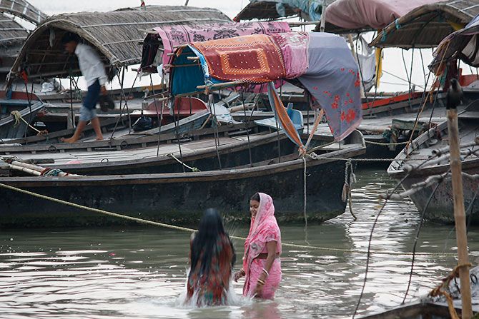 Women take a dip on the banks of the Sangam