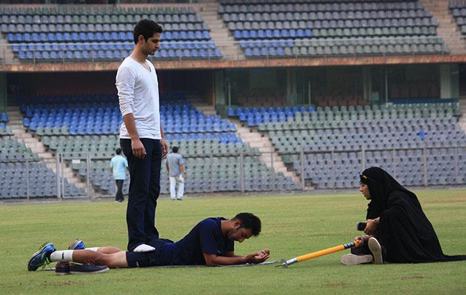 Arsalan Dungroo helps Ian Dev Singh Chauhan with his workout as their media manager talks to them