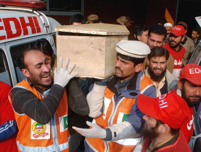 Rescue workers and family members carry the coffin of a student killed during the attack on the Army Public School in Peshawar
