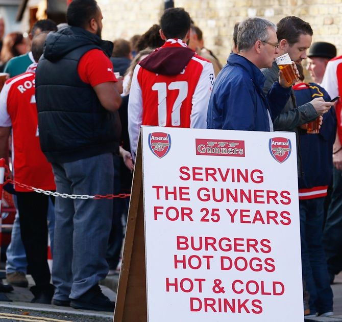 Arsenal fans pose outside the stadium