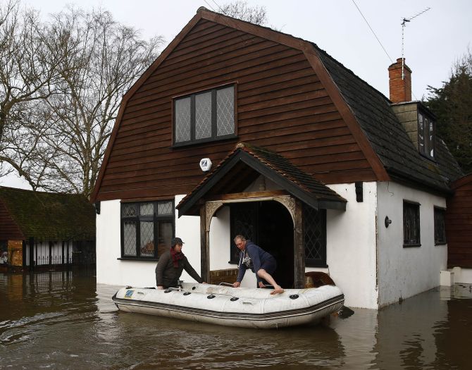 A resident is rescued from his house after the river Thames flooded the village of Wraysbury, southern England, on Monday.