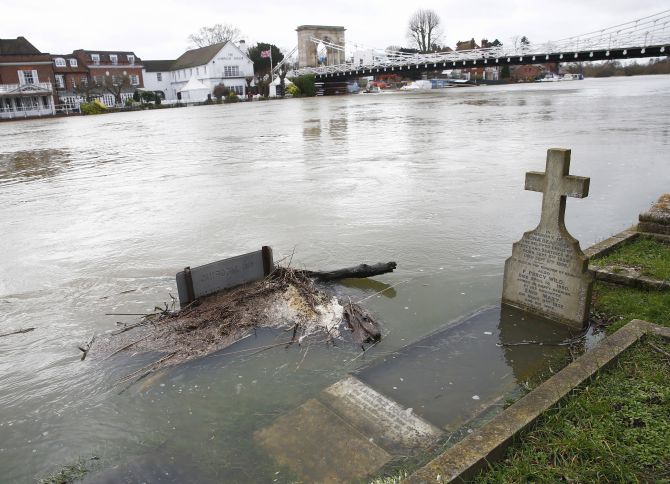 The river Thames floods into a graveyard at All Saints church in Marlow, southern England