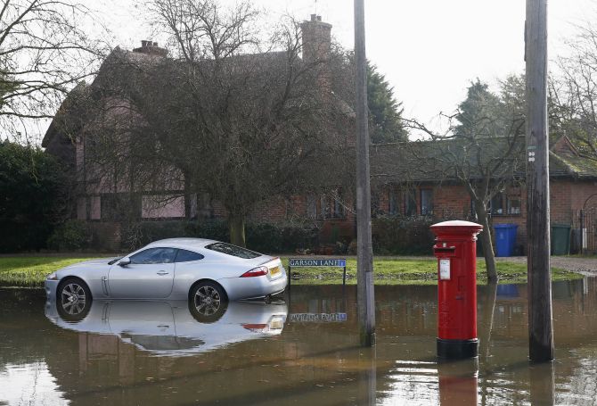 A car is seen surrounded by water after the river Thames flooded the village of Wraysbury, southern England.