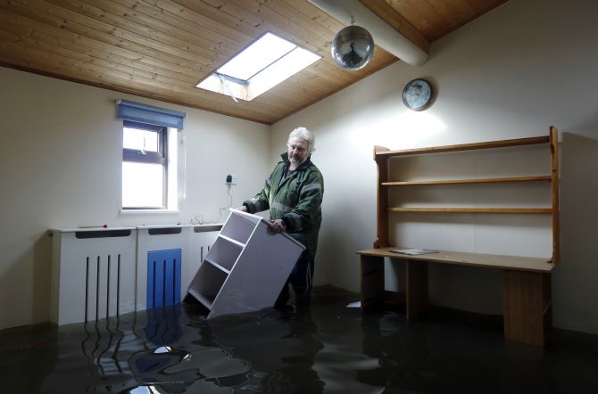Resident, builder Dave Donaldson moves furniture from one of the flooded rooms of his home at Burrowbridge on the Somerset Levels in south west England 