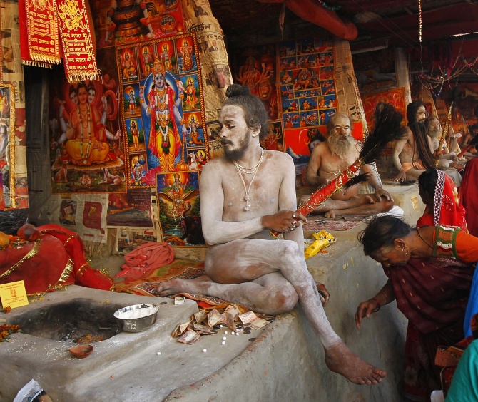 A Hindu woman seeks a Naga sadhu's blessings in Kolkata.