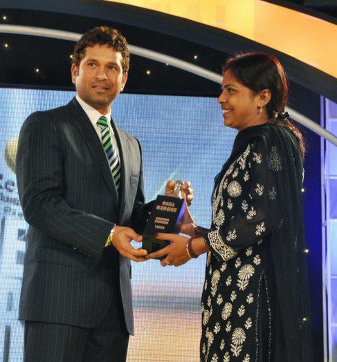 Naseema receives an award felicitating her from cricketer Sachin Tendulkar