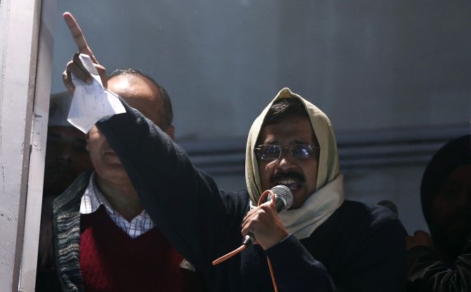 Delhi's Chief Minister Arvind Kejriwal shows his resignation to his supporters while addressing them from his party headquarters in New Delhi on Friday