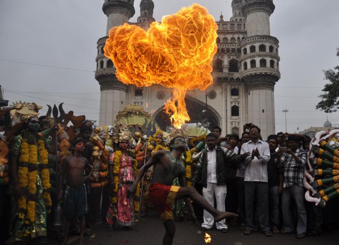 A performer blows fire from his mouth during Bonalu celebrations in Hyderabad