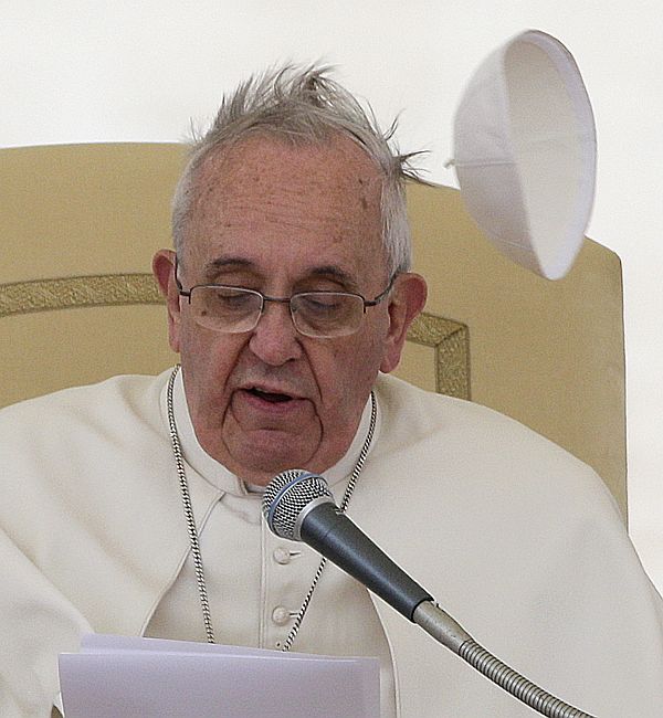 A gust of wind blows Pope Francis's skull cap off during his general audience in Saint Peter's square