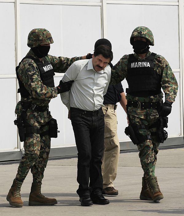 Joaquin Shorty Guzman is escorted by soldiers during a presentation at the Navy's airstrip in Mexico City