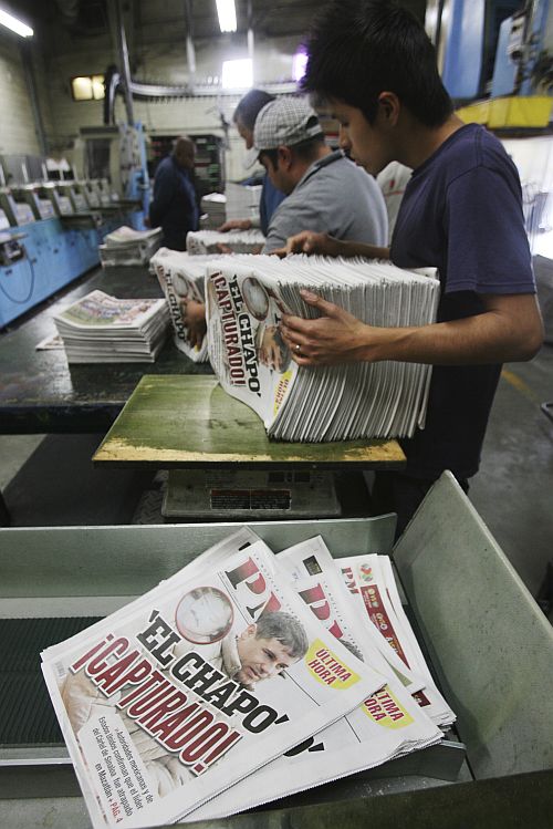 Workers sort the freshly printed afternoon daily PM, with the headline reading El Chapo captured, at the newspaper's printing house in Ciudad Juarez