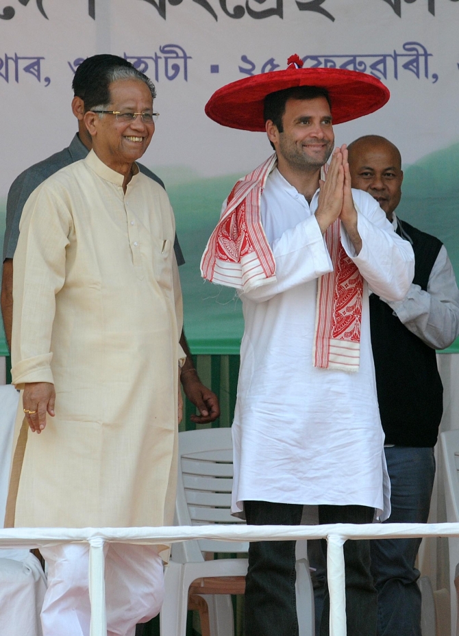 Congress Vice President, wearing a traditional Assamese hat and shawl, greets his supporters at a rally in Guwahati, as CM Tarun Gogoi stands by his side