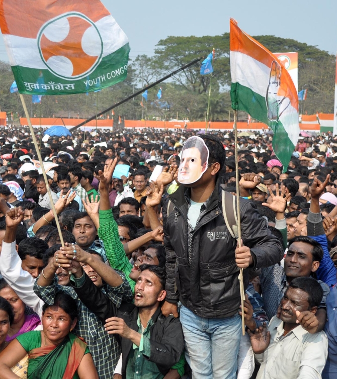 A Congress supporter wears a mask of Rahul at the rally