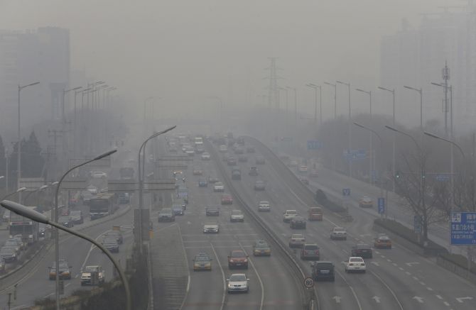 Cars drive on the second ring road amid the heavy haze in Beijing on Tuesday.
