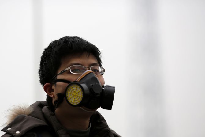 A man wearing a mask makes his way amid heavy smog in Beijing.
