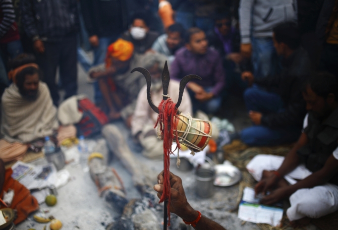 A hand of a Sadhu holds a trident at the premises of a temple during the Shivaratri festival.