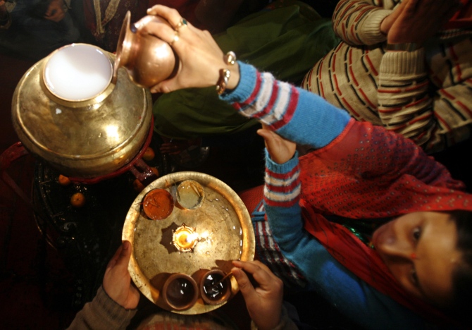 A Kashmiri woman pours milk into a sacred pot during Mahashivratri in Srinagar.