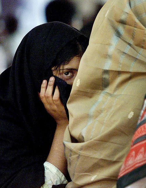 A girl hides from the camera during a sit-in in to protest against communal violence