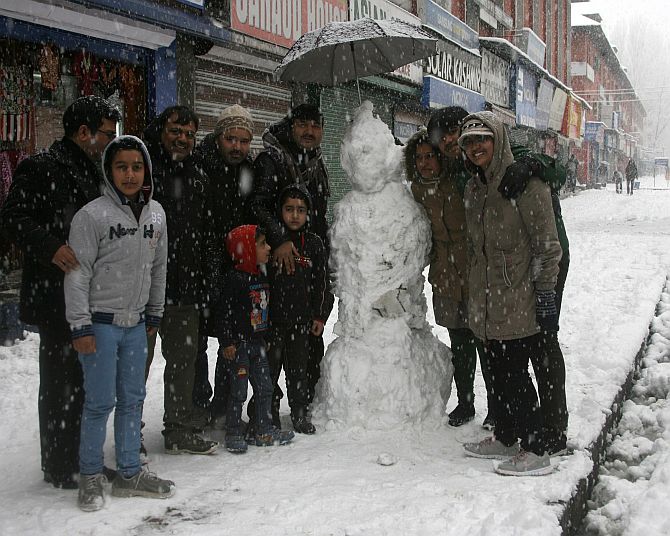 Tourists pose with a snowman in Srinagar