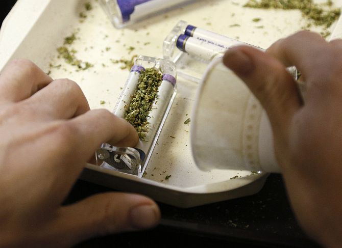 A worker rolls marijuana joints for sale at the Botanacare marijuana store