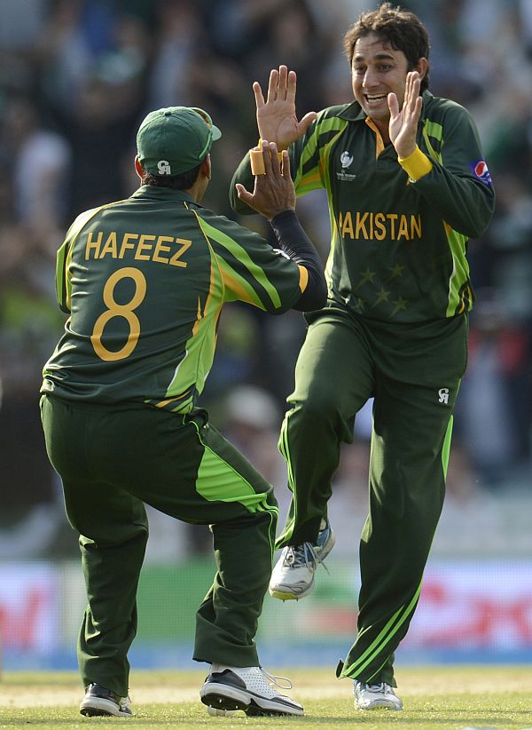 Pakistan's Saeed Ajmal and Mohammad Hafeez celebrate the fall of a wicket during a match against India