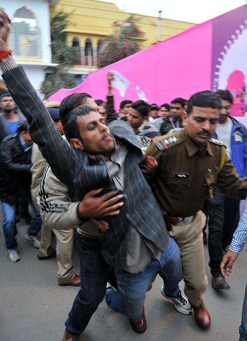 A protestor being whisked away by the police