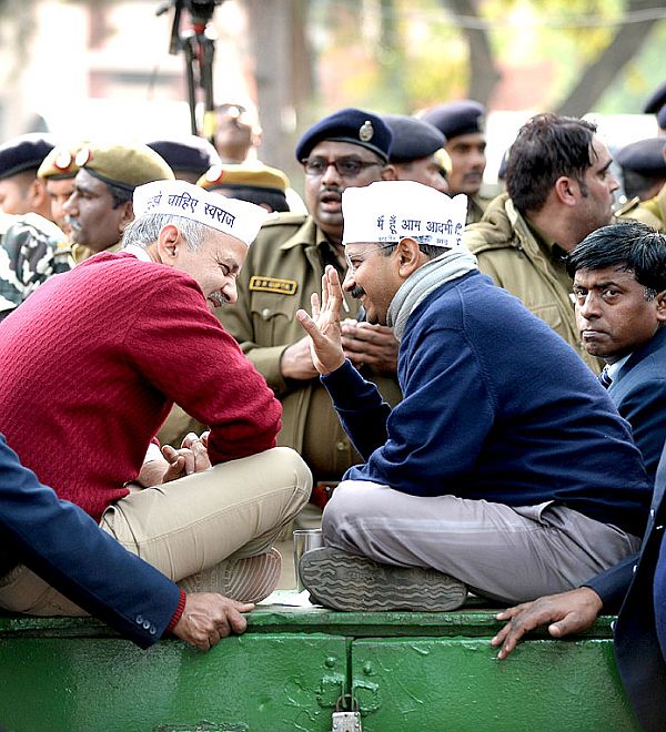 Aam Aadmi Party chief Arvind Kejriwal and party leader Manish Sisodia chat during a protest in New Delhi 