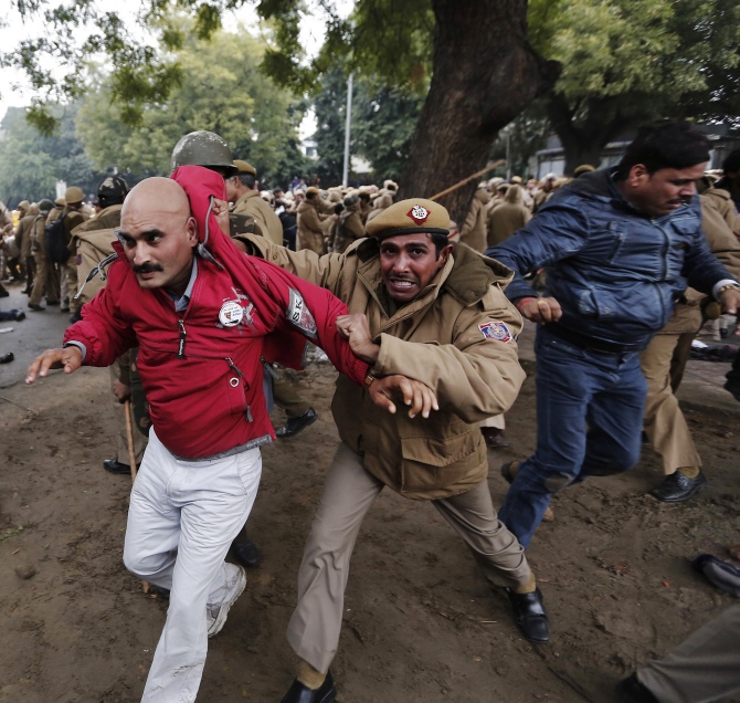 A policeman drags a supporter of the Aam Aadmi Party from the site of a protest led by Delhi Chief Minister Arvind Kejriwal in New Delhi