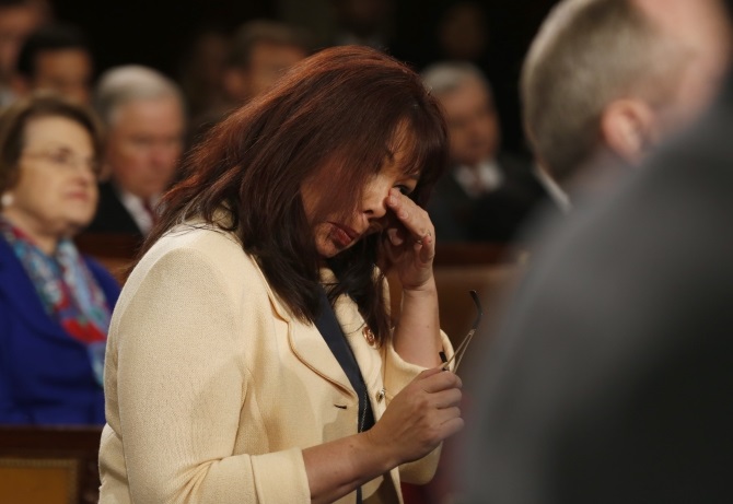 US Representative Tammy Duckworth wipes tears from her eyes during a standing ovation for US Army Ranger Sgt First Class Cory Remsburg, injured while serving in Afghanistan, who was a guest in first lady Michelle Obama's box during President Barack Obama's State of the Union speech on Capitol Hill
