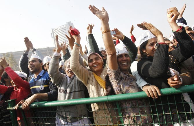 Supporters of Aam Aadmi Party cheer after its leader Arvind Kejriwal took an oath as the new chief minister of Delhi.