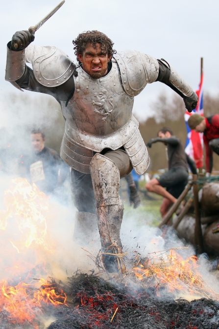 A competitor dressed as a knight runs through a fire during the Tough Guy Challenge in Telford, England