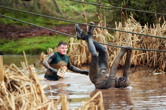A competitor tries to avoid the water during the Tough Guy Challenge in Telford, England