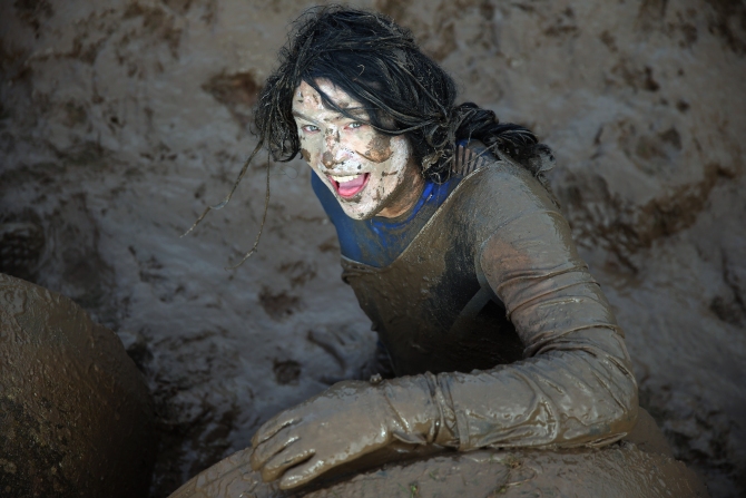 A competitor pulls herself out of a tunnel during the Tough Guy Challenge on January 26, 2014 in Telford, England.