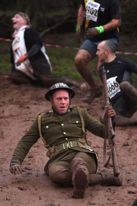 A competitor slides down a mud banking during the Tough Guy Challenge in Telford, England.