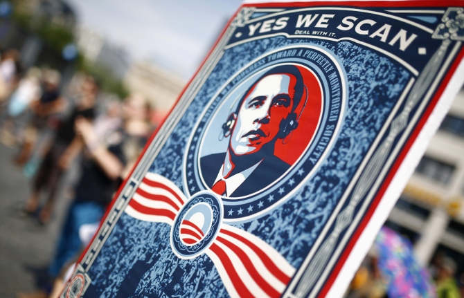 A protester holds a placard showing U S President Barack Obama with the phrase Yes we scan during a demonstration against the National Security Agency and in support of whistleblower Edward Snowden in Frankfurt