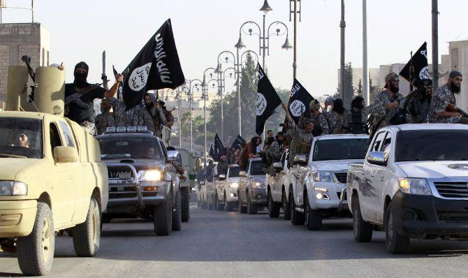 Militant Islamist fighters parade on military vehicles along the streets of northern Raqqa province after they announced the formation of a new Islamist state.