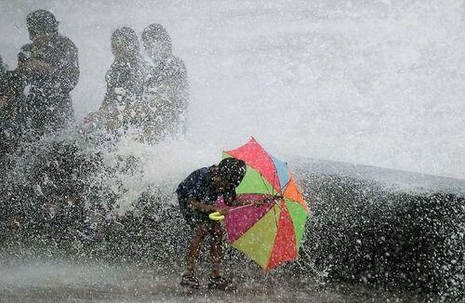 A boy enjoys the hide tide during a high tide at Marine Drive in Mumbai