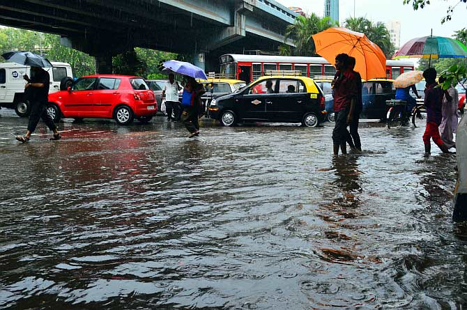People wade through a water-logged road near Hindamata, Mumbai