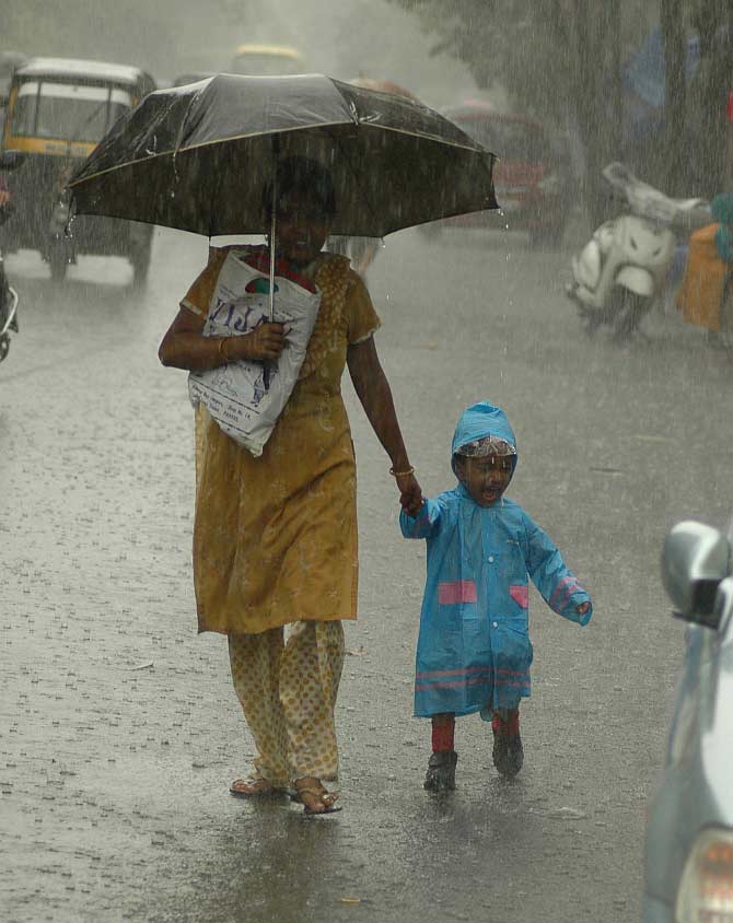 A woman and her child enjoy a walk in the rain