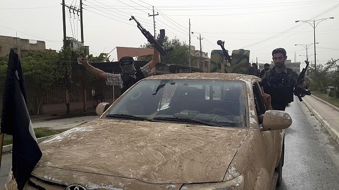 ISIS terrorists celebrate on vehicles seized from Iraqi security forces. Photograph: Reuters