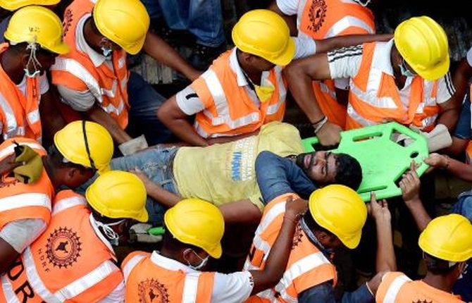 NDRF authorities rescue a man from the debris of the building in Chennai