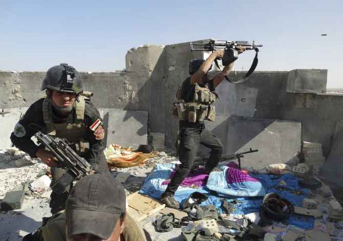 Iraqi security forces engage in a gun battle with ISIS fighters in Tikrit.