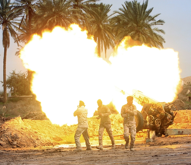 Iraqi security forces fire an artillery gun during clashes with the Islamic State in Iraq and Syria in Jurf al-Sakhar