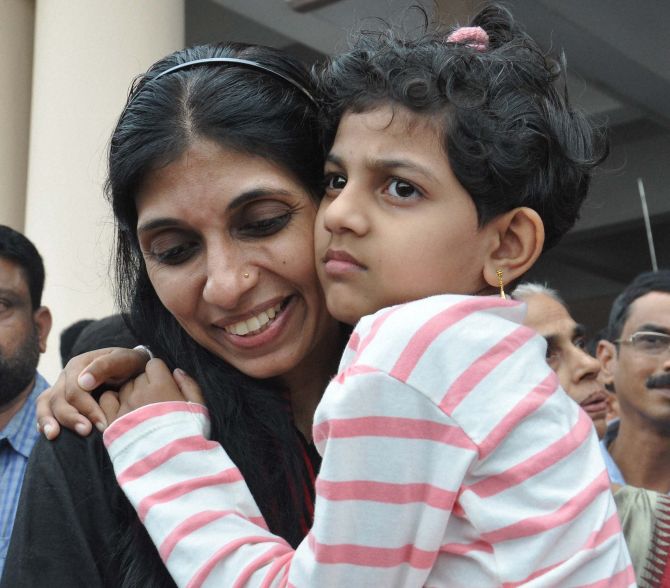 Maureen, one of then nurses who were stranded in the territory held by Islamic extremists in Iraq, holding her kid upon arrival at the airport in Kochi on Saturday