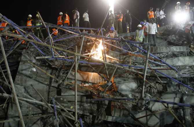 Rescue workers conduct a search operation for survivors at the site of the collapsed building near Chennai 