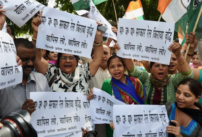 Congress activists display placards during a protest against the Rail Budget outside the residence of Railway Minister DV Sadananda Gowda.
