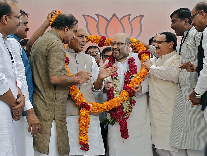 Shah receives a garland by BJP members in New Delhi 