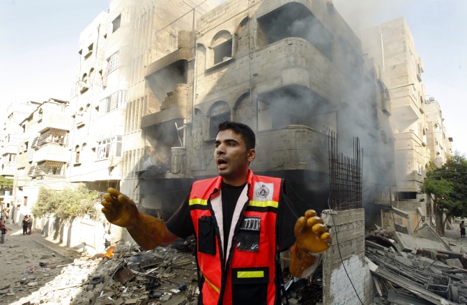 A member of the civil defence reacts after what police said was an Israeli air strike on a house, in Gaza City.